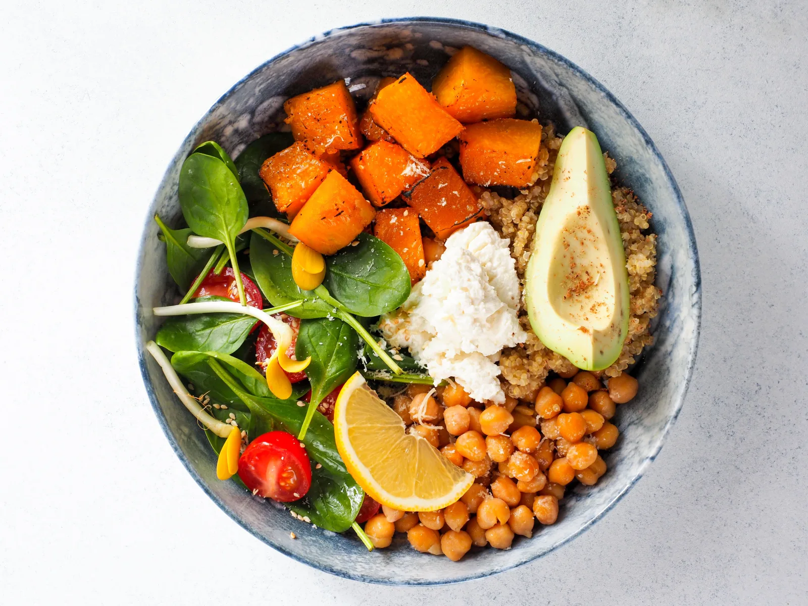 Bowl mit Süßkartoffel, Kichererbsen, Avocado und Blattsalat von oben